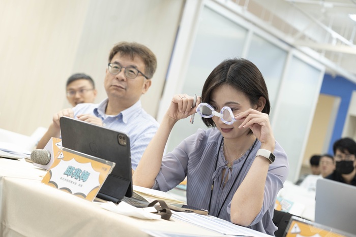 新北市青年局長邱兆梅戴上學員製作的老花眼鏡體驗銀髮族視力模糊情境